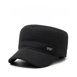 Detail of black winter wool baseball cap with warm ear flaps and sports style metal badge