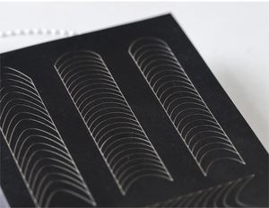 Macro shot of curved French tip nail guide stickers for airbrush stencil designs