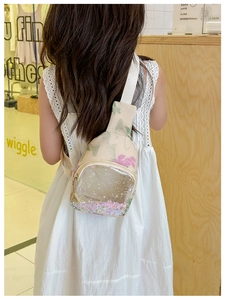 Detail of floral kids chest bag featuring a transparent PVC pocket with colorful sequins