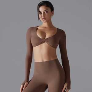 Dettaglio completo yoga marrone con crop top incrociato e maniche con foro per pollice