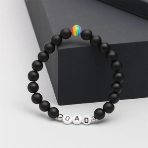 Close-up of black matte beads and DAD letter beads on a tiger eye stone bracelet