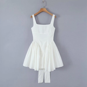 Detailed close-up of white sun dress showing delicate pleats and a flared silhouette