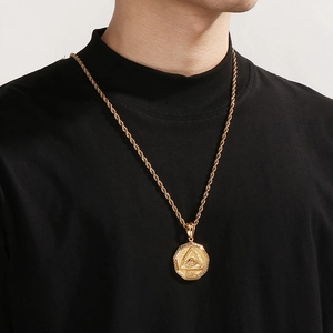 Detailed view of gold Eye of Providence pendant with rope chain on male model