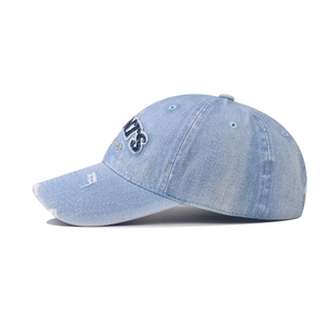 Close-up of distressed denim baseball cap featuring 3D embroidered logo and worn brim details