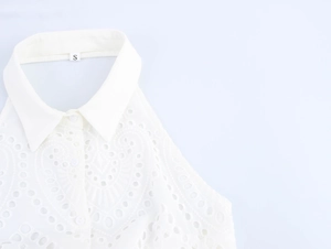 Dettaglio dell'abito in pizzo bianco con colletto a camicia ed etichetta taglia S