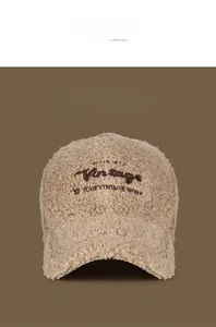 Detail of embroidered Vintage lettering on soft beige sherpa fleece baseball cap texture