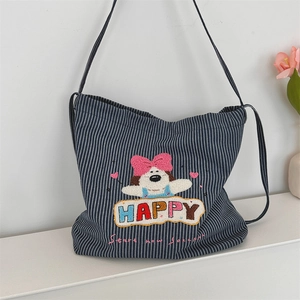 Detail of blue and white striped canvas bag featuring cute puppy cartoon embroidery