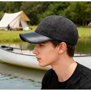 Detail of dark grey baseball cap with sports logo and leather brim for elderly men