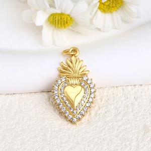 Macro shot of gold-plated heart pendant with crown detail and inlaid zircon stones