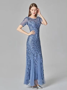 Full view of blue sequin evening dress featuring leaf patterns and ruffled mesh hemline