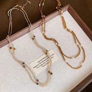 Vintage stainless steel beaded necklace set with tiger eye stones and pearls displayed in a tray
