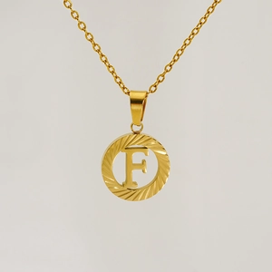Detailed view of an 18K gold-plated hollow round pendant with letter F on a thin chain