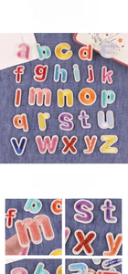 Detailed macro view of colorful embroidered alphabet patches on blue denim fabric
