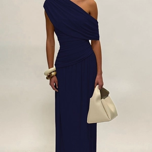 Close-up of elegant dark blue asymmetrical off-shoulder maxi dress with ruched fabric details