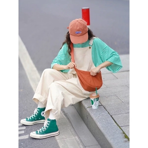 Outdoor street style showcasing an orange nylon crossbody bag with casual summer outfit