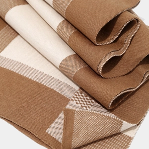 Close-up of thick knitted plaid scarf in brown and beige colors for winter warmth