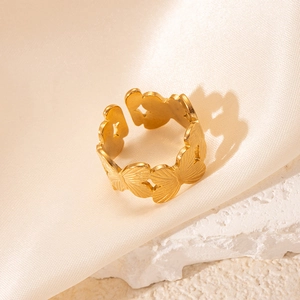 Détail macro de la bague ajustable dorée avec motifs de papillons embossés sur anneau large
