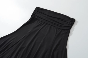 Détail des plis à la taille et du tissu drapé sur la jupe midi noire en tricot