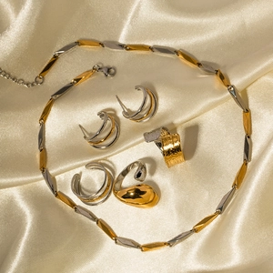 Elegant two-tone gold and silver minimalist jewelry set on champagne silk fabric
