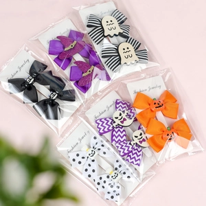 Macro view of Halloween double bow hair clips with pumpkin and ghost resin details