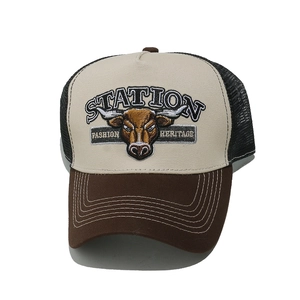 Detailed close-up of retro bull head embroidery on a beige and brown trucker cap