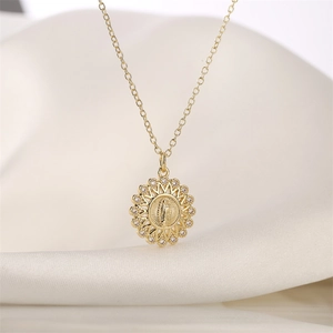 Detailed close-up of golden sunburst pendant with zircon micro-paving on silk fabric
