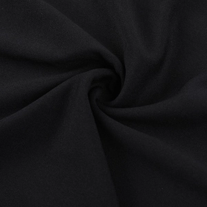 Vue macro du tissu plissé noir avec pliage en spirale sur une robe à épaules dénudées