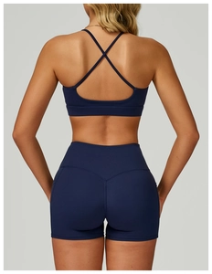 Detail of cross back straps on navy blue sports bra and high waist fitness shorts