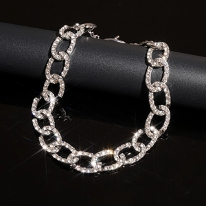 Close-up of sparkling silver Cuban link chain with full rhinestones on black background
