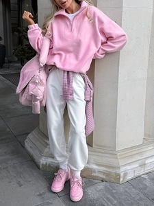 Detail of pink fleece half-zip sweatshirt with soft texture and white joggers