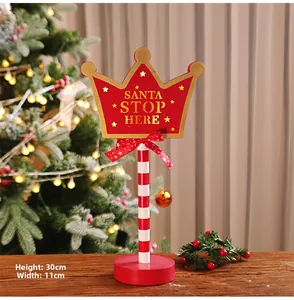 Detail showing red wooden Santa Stop Here crown sign with 30cm height dimensions