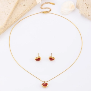 Minimalist gold necklace and earrings set with red heart pendants on a white background