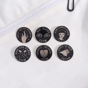 Set of 6 black enamel badges featuring creative artistic designs on white fabric