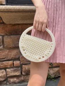 Handmade pearl beaded round handbag with circular cutout handle and white glossy finish