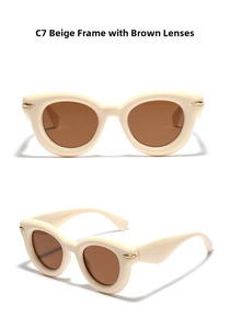 Close-up of beige cat eye sunglasses featuring gold rivets and tinted brown lenses