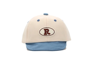 Vue détaillée de près d'une casquette de baseball pour bébé avec écusson brodé lettre R