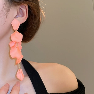 Detailed shot of pink rose petal tassel earrings with elegant matte finish on model
