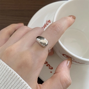 Close-up of polished 925 sterling silver ring with irregular water drop design on hand