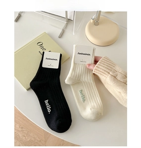 Close-up of combed cotton mid-calf socks with hello text and ribbed texture