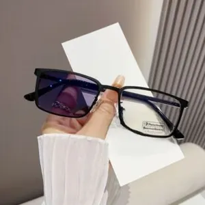 Detail of photochromic lenses changing color on black square frame glasses with blue light filter
