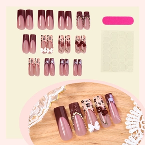 Burgundy leopard print press-on nails with 3D cherry and bow details on light background