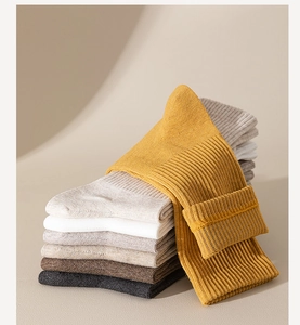 Close-up of stacked colorful ribbed cotton socks in mustard yellow, beige, and grey tones