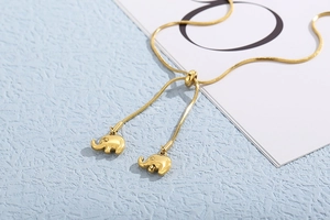 Macro shot of gold snake chain featuring adjustable slide clasp and twin elephant charms
