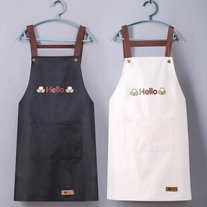 Detail of waterproof kitchen aprons with large front pockets and stylish cross back straps