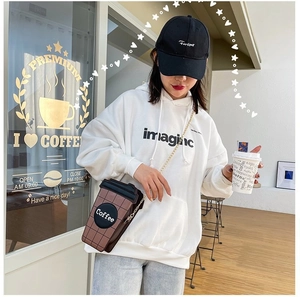 Detail of coffee cup shaped crossbody bag with brown check pattern and gold chain strap