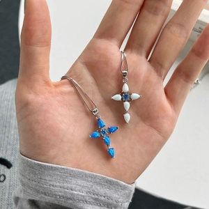 Detailed close-up of S925 sterling silver cross pendants with blue and white opal stones