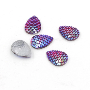 Macro shot of five teardrop resin charms with fish scale texture and purple-blue AB plating
