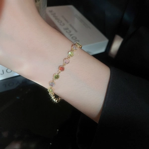 Close-up of gold plated bracelet with colorful round zircons on model wrist