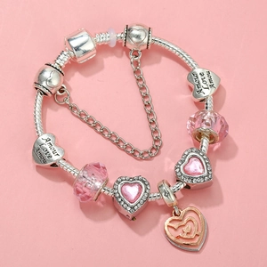Detailed macro view of silver-plated heart beads and pink crystals on a charm bracelet