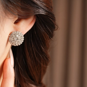 Gros plan d'une boucle d'oreille en strass argenté portée par un mannequin élégant